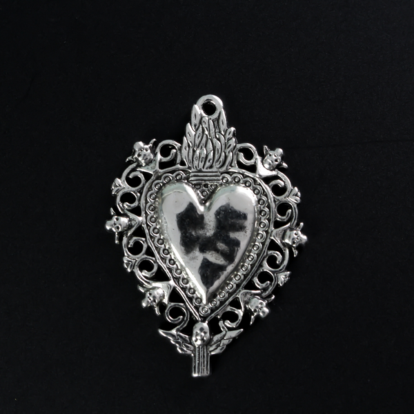 Unique Sacred Heart Milagro style pendant with skulls around the border a winged angel at the bottom.