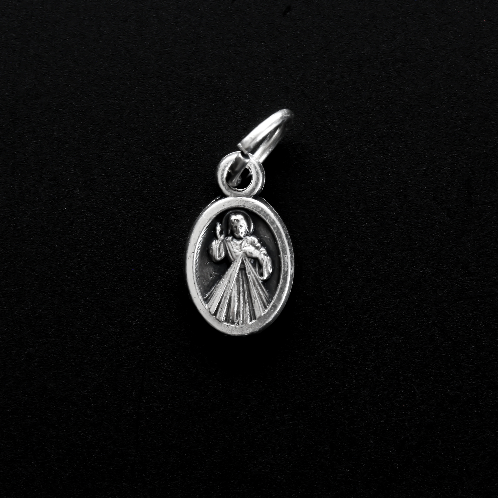 Tiny Divine Mercy of Jesus medal with "Pray For Us" written in Spanish on the backside: Ruega Por Nosotros.