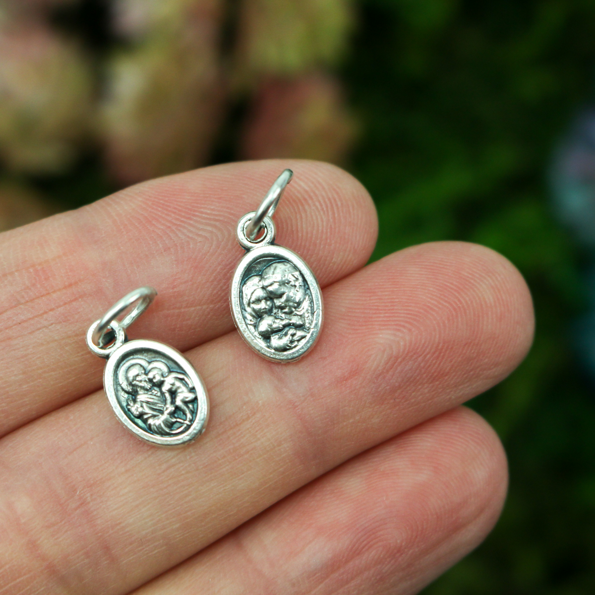 1/2" long medal that depicts Saint Joseph holding the child Jesus on one side and the Holy Family depicted on the other side