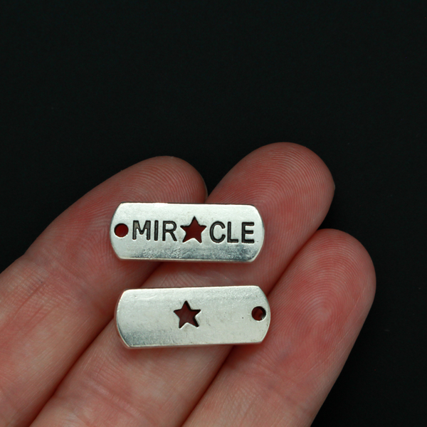 Rectangle antiqued silver-tone charms with an inspirational message of "MIRACLE" with a cut out star shape for the A
