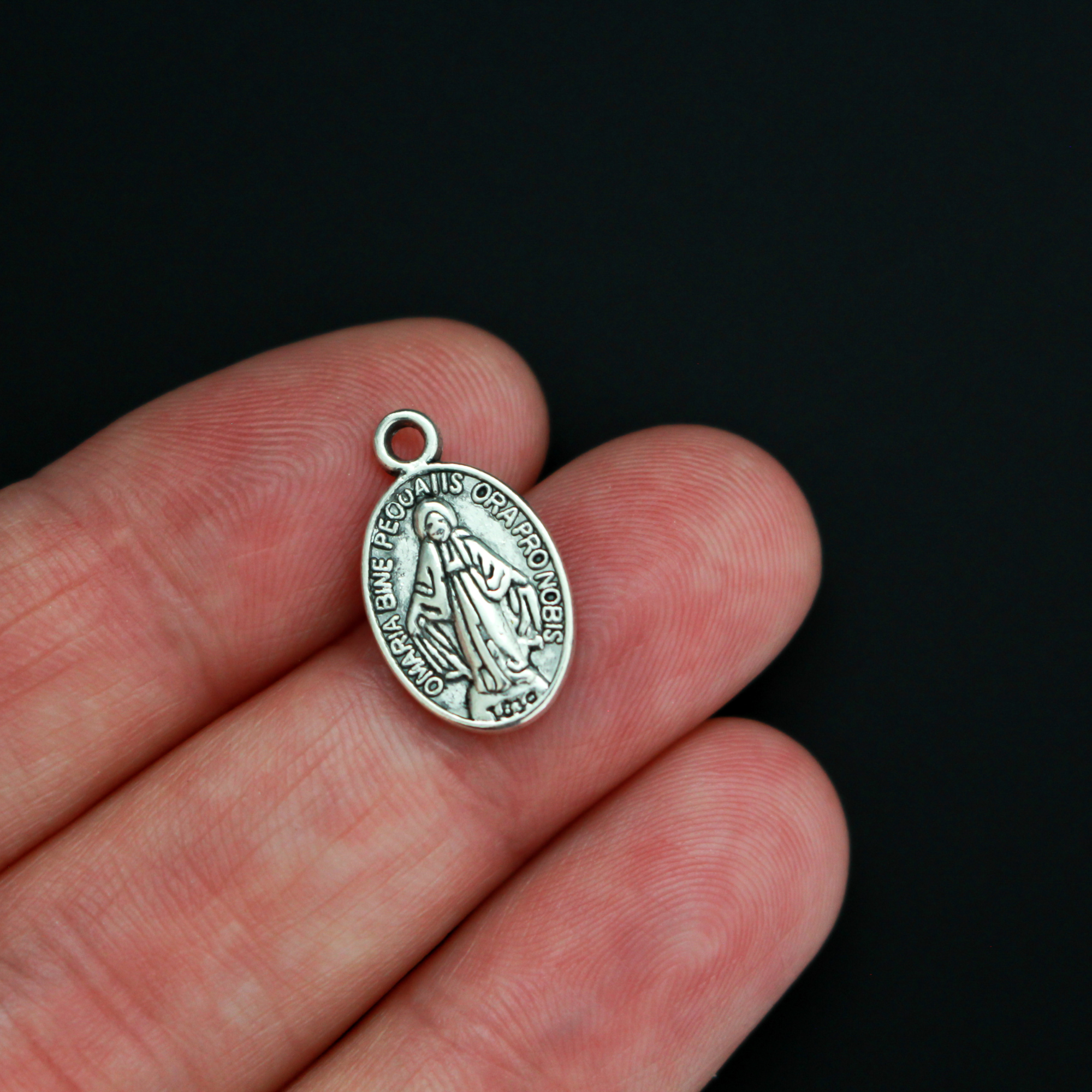 Miraculous Mary medal with the Latin inscription"O' Maria Sine Peccatis Ora Pro Nobis