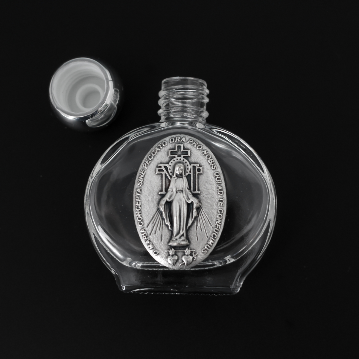 Glass holy water bottle with a metal embossed plaque of The Miraculous Medal on the front. Plastic screw on cap that is a shiny silver tone color.