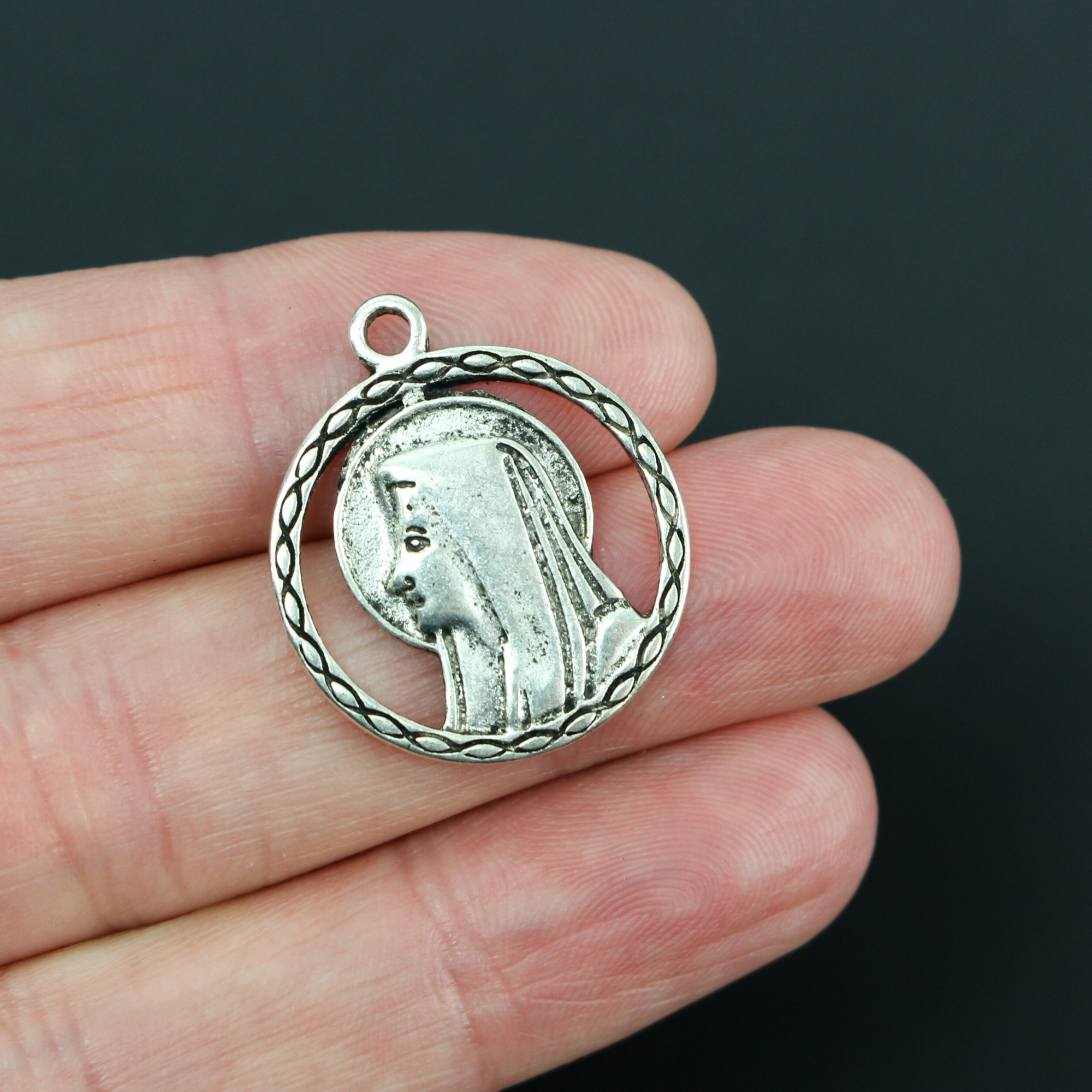 our lady of lourdes pendant with a cutout filigree design