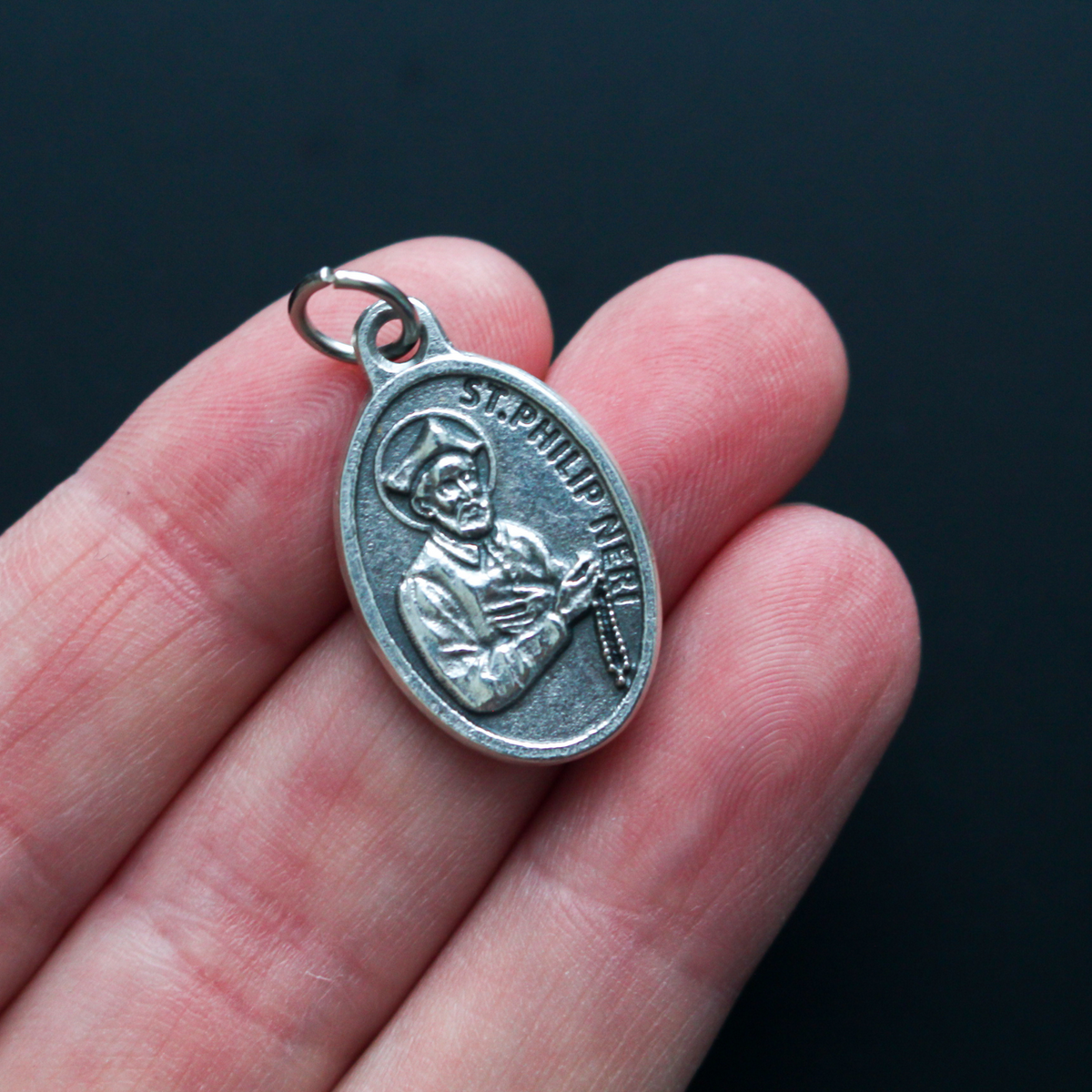 1" oval silver oxidized St. Philip Neri medal that depicts the saint on the front and Pray For Us on the back