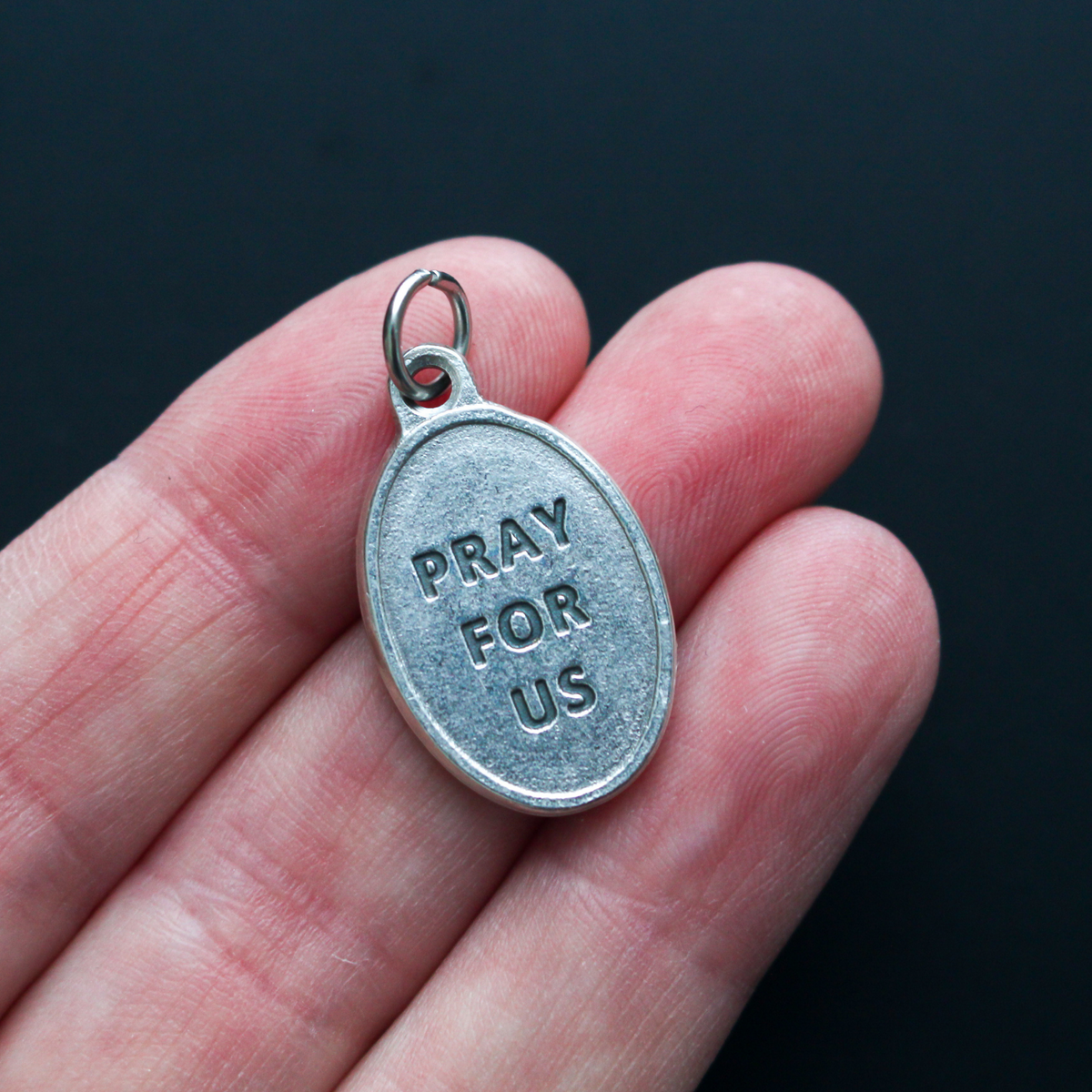 1" oval silver oxidized St. Philip Neri medal that depicts the saint on the front and Pray For Us on the back