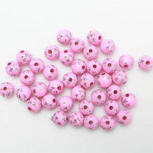 8mm Round pink opaque beads that have a silver star design etched into them. 