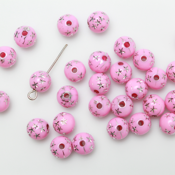 8mm Round pink opaque beads that have a silver star design etched into them. 