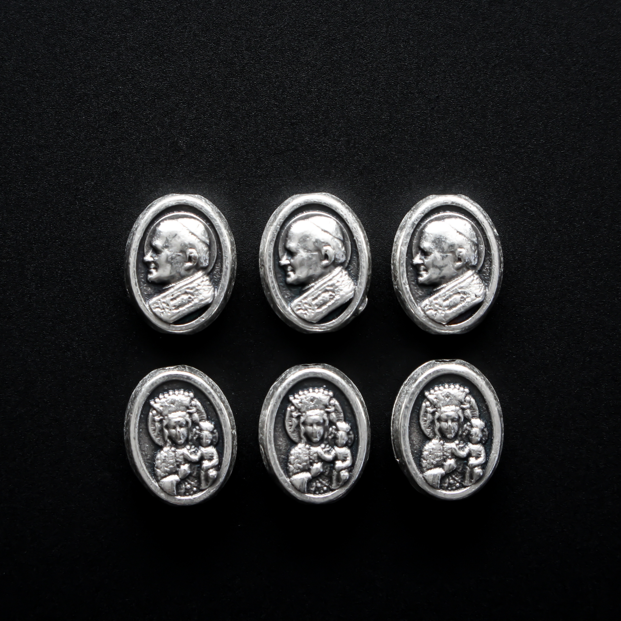 small die cast metal beads that depict Our Lady of Czestochowa on one side and Pope John Paul II on the other side.