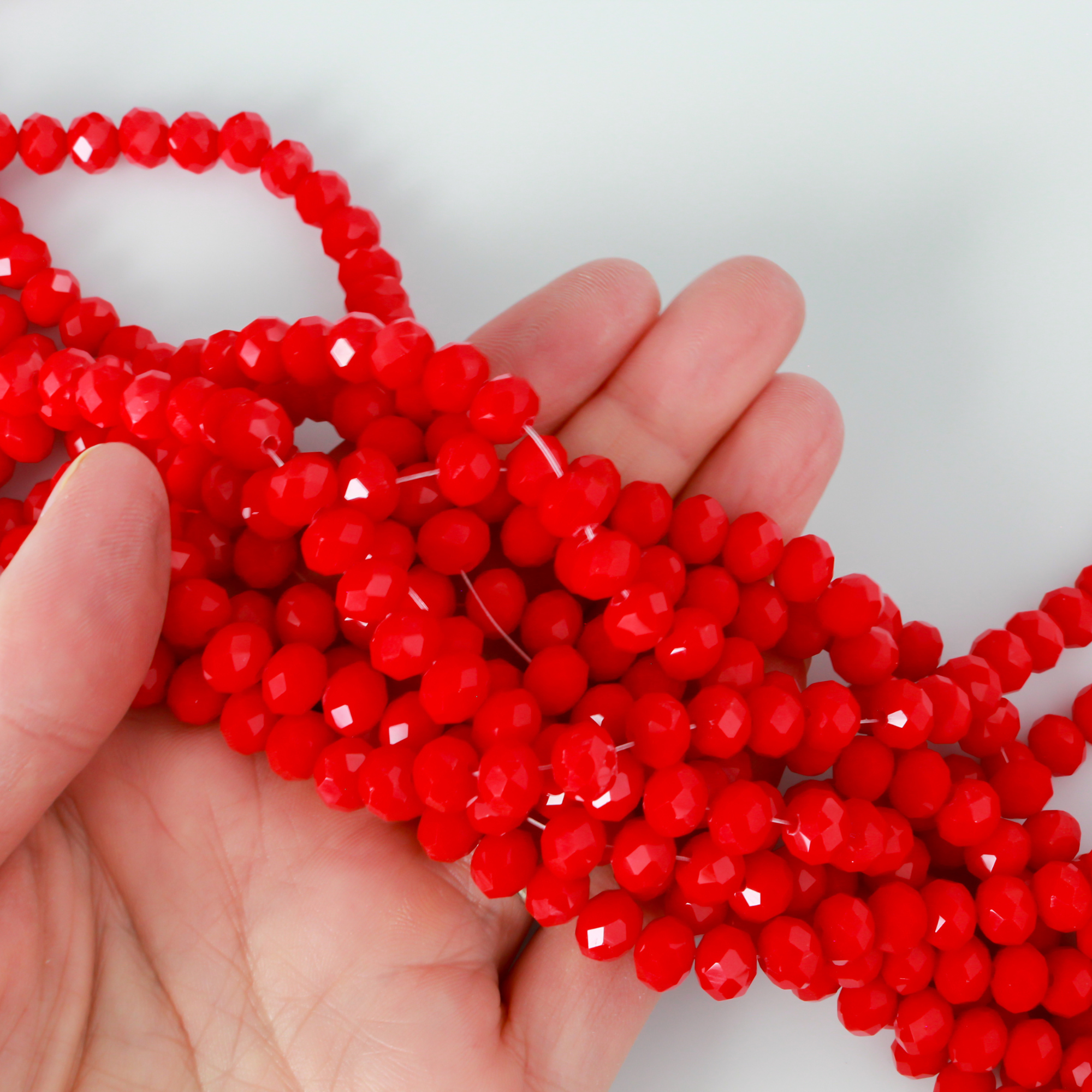Glass faceted rondelle beads in an fire brick red color.
