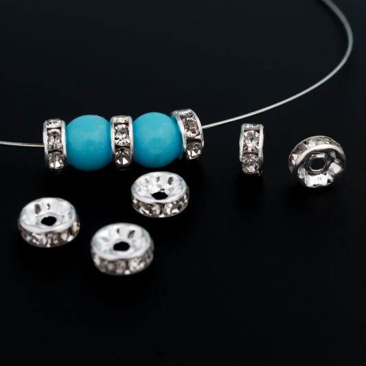 Rhinestone spacer beads that are 8mm in diameter. The bead is brass with a silver plating and the rhinestones are grade A.