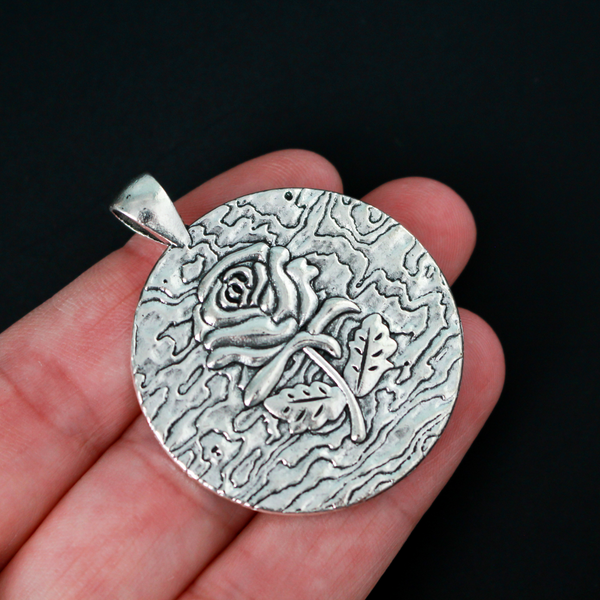 Three silver cabochon settings with a detailed rose on the backside. The tray fits 35mm cabochons which are included