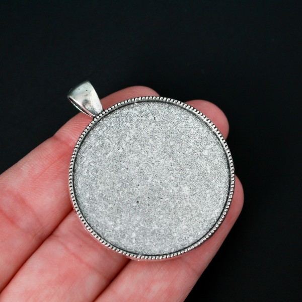 Three silver cabochon settings with a detailed rose on the backside. The tray fits 35mm cabochons which are included
