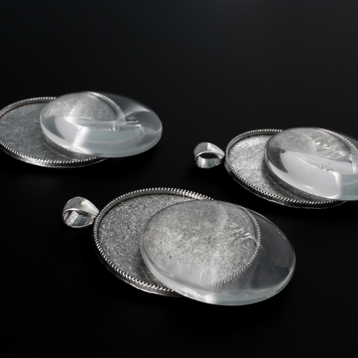 Three silver cabochon settings with a detailed rose on the backside. The tray fits 35mm cabochons which are included