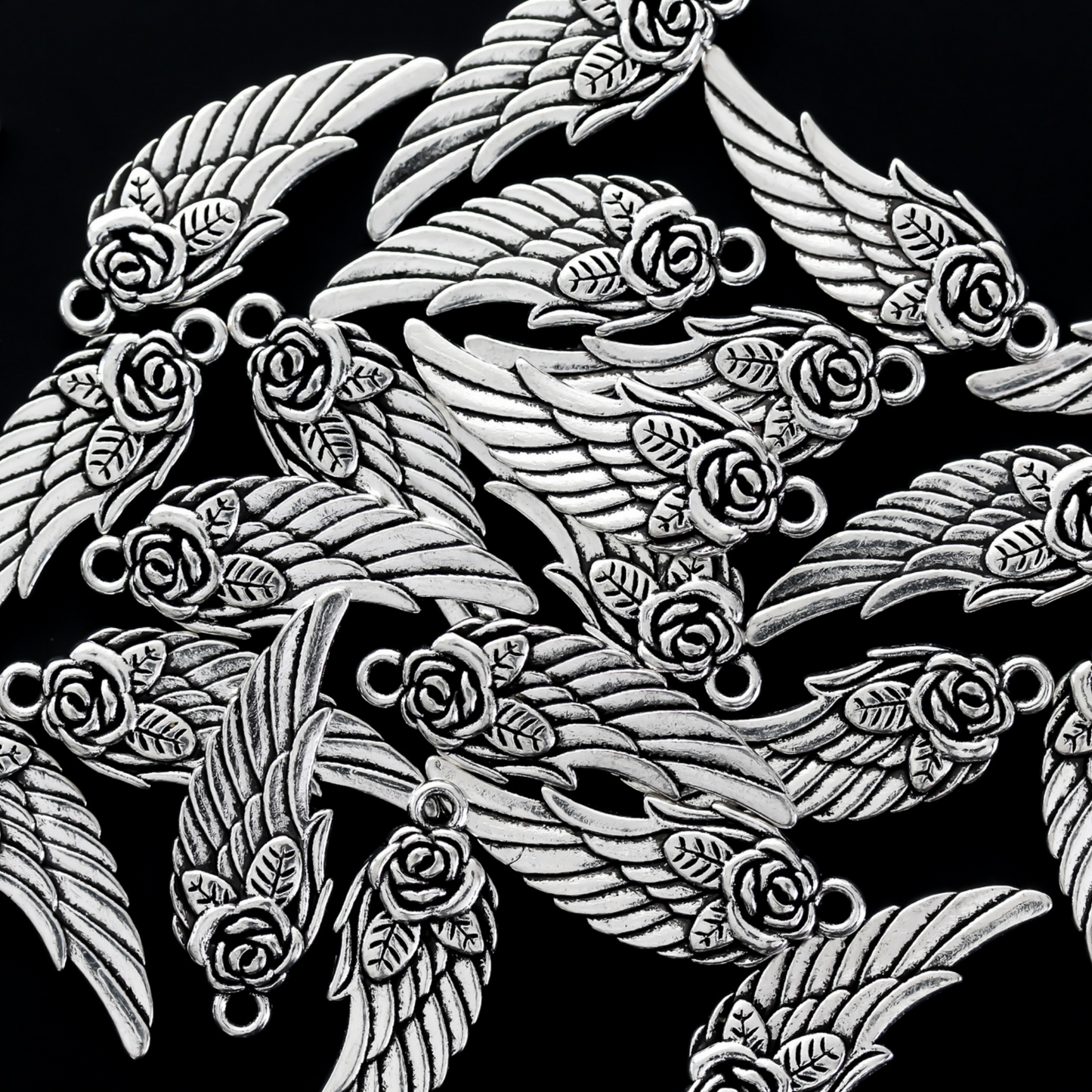 Double-sided wing charm with a rose detail at the top. The charm looks the same on both sides, 32mm long