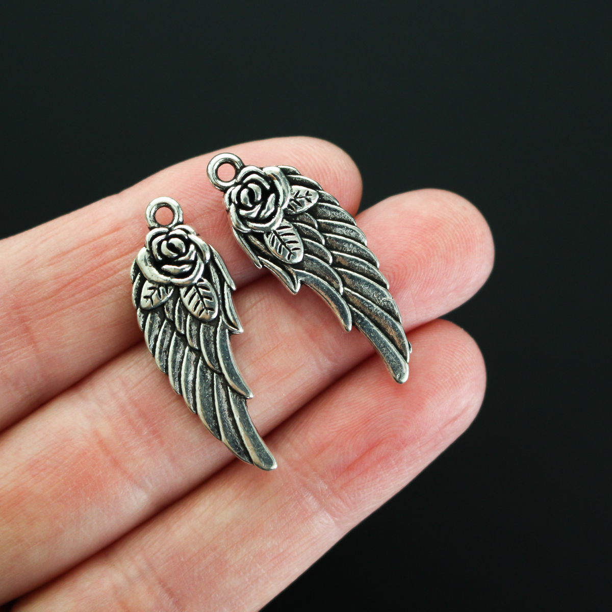 Double-sided wing charm with a rose detail at the top. The charm looks the same on both sides, 32mm long