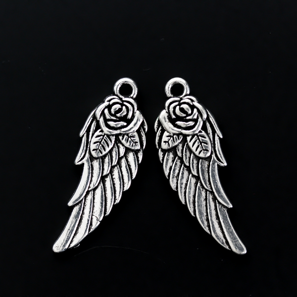 Double-sided wing charm with a rose detail at the top. The charm looks the same on both sides, 32mm long
