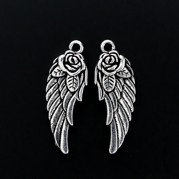 Double-sided wing charm with a rose detail at the top. The charm looks the same on both sides, 32mm long