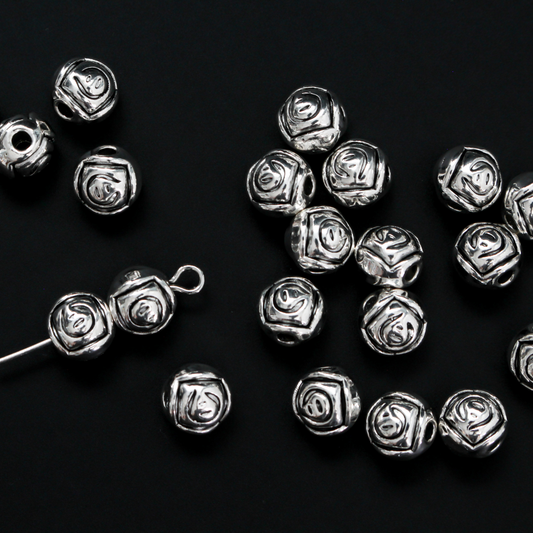 Antiqued silver-tone metal beads with a rosebud pattern 6.6mm in diameter, 60 beads total.