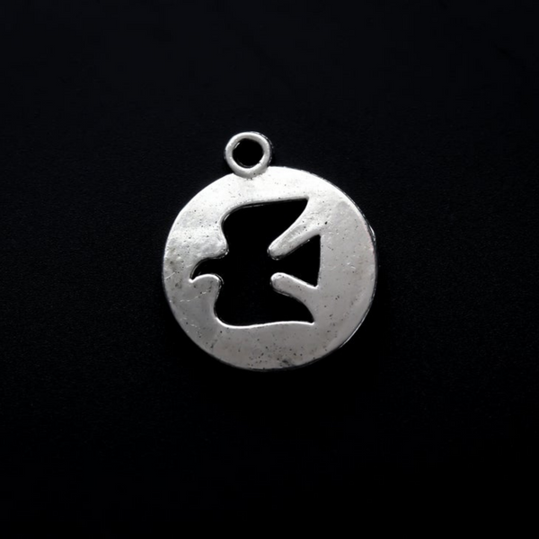 Round silver-tone charm with a cut-out dove in the center.