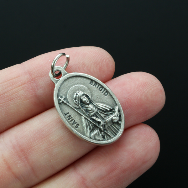 Saint Brigid of Kildare oval medal that depicts the saint on the front and "Pray For Us" on the back.