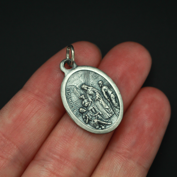 Saint Hedwig of Silesia medal, also known as Hedwig of Andechs. This medals depicts the saint on the front helping the poor. Her name is written in the Spanish translation: Santa Eduvigis. The reverse side of the medal is marked "Pray for us"