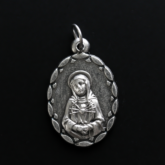 Our Lady of the Seven Sorrows medal that depicts the Virgin Mary on the front, her heart is pierced by seven swords which represent the seven sorrows.