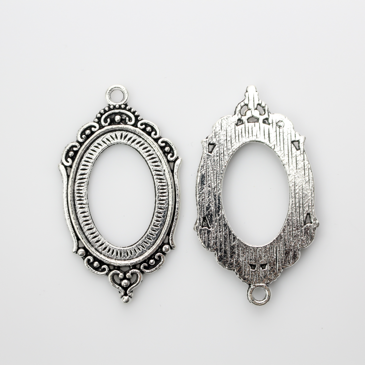 Ornate oval antiqued silver style cabochon setting with an open back
