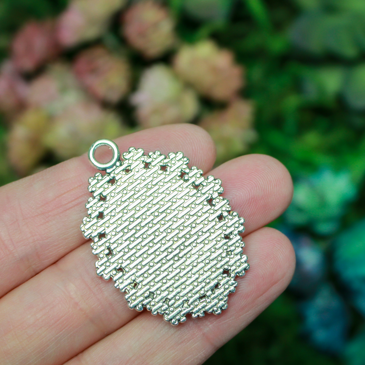 Silver ornate oval bezel tray setting with an ornate flower embellished trim.
