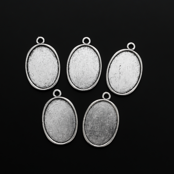 Flat oval pendant cabochon setting in an antiqued silver tone color. This is a plain edge bezel cup with a 25mm x 18mm tray