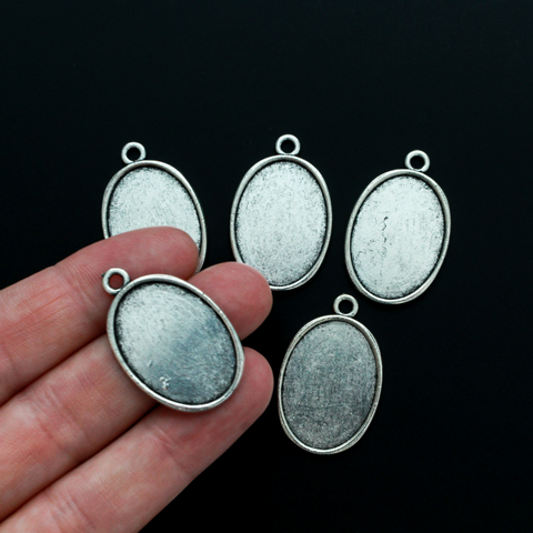 Flat oval pendant cabochon setting in an antiqued silver tone color. This is a plain edge bezel cup with a 25mm x 18mm tray
