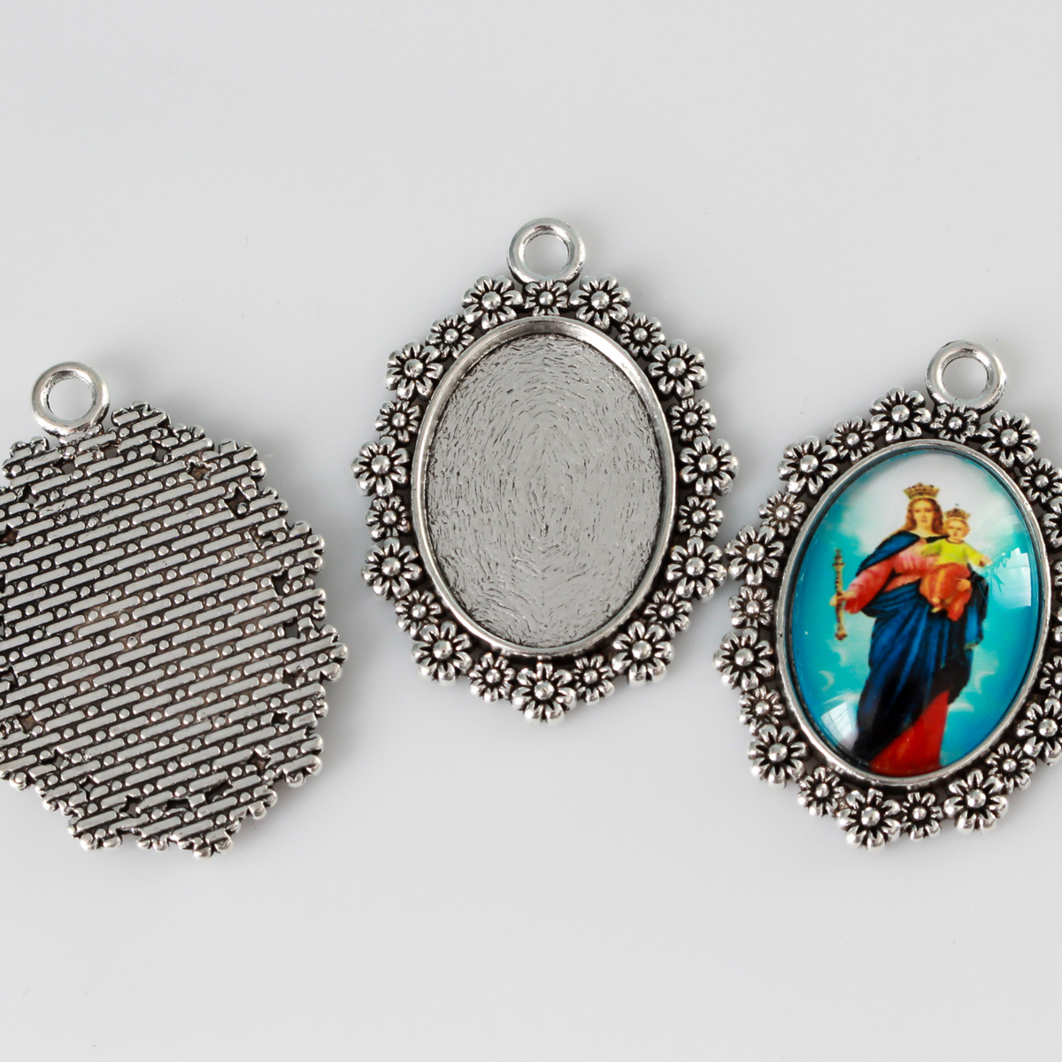 Silver ornate oval bezel tray setting with an ornate flower embellished trim.