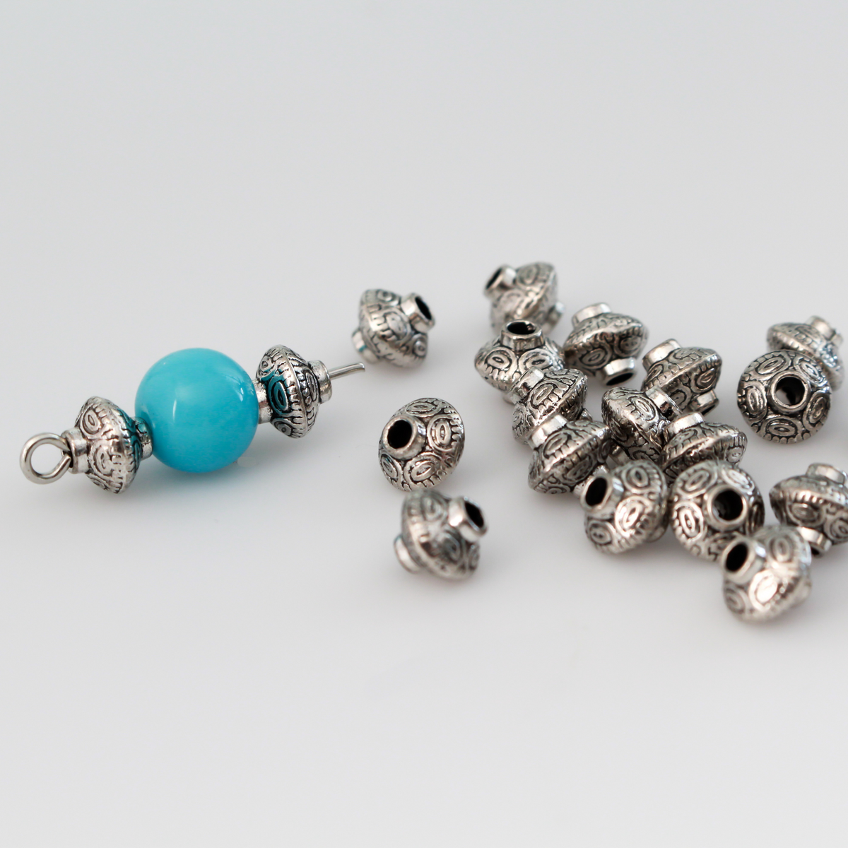 50 metal bicone shaped spacer beads with an antiqued silver finish and a carved dot pattern
