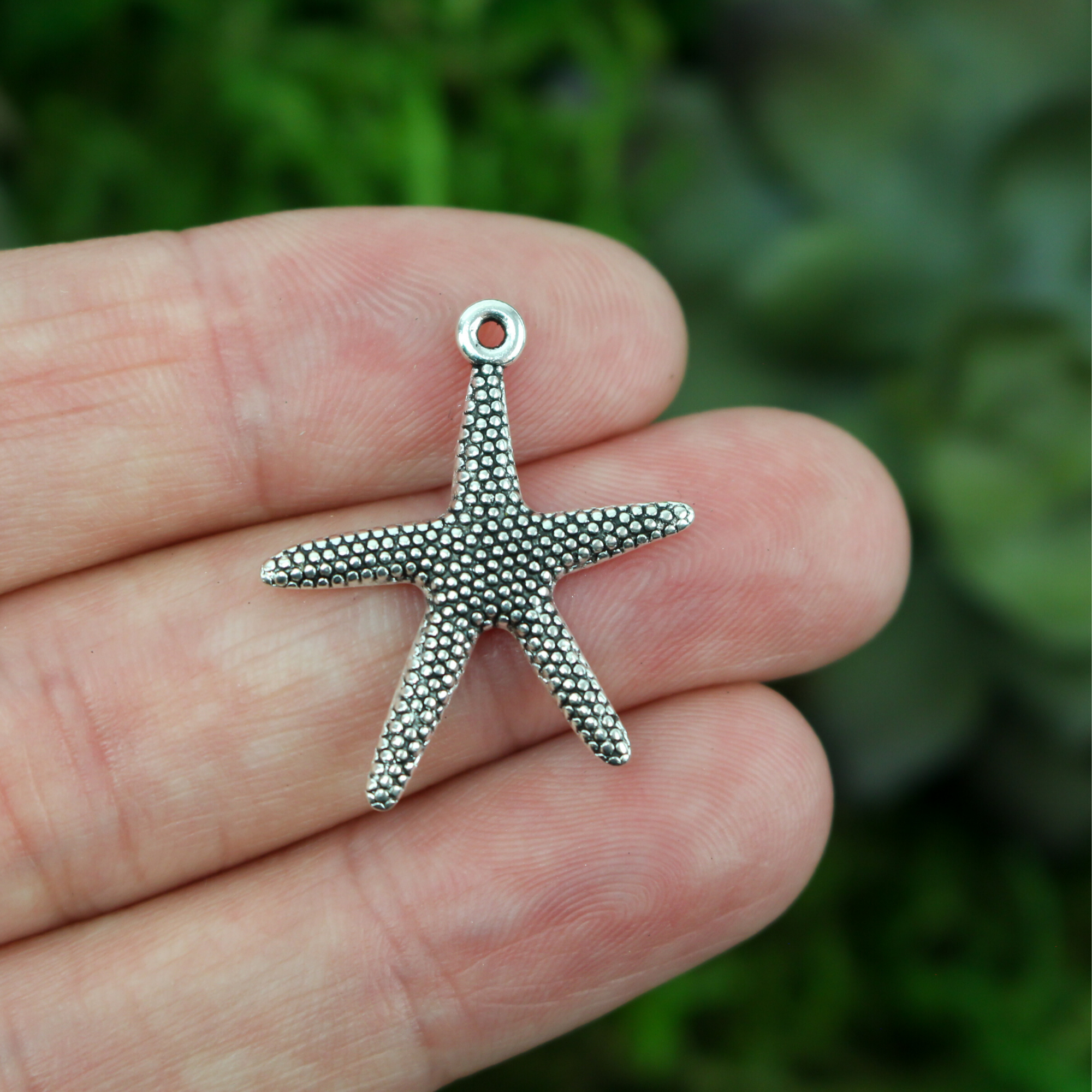 silver tone starfish shaped pendant charm.