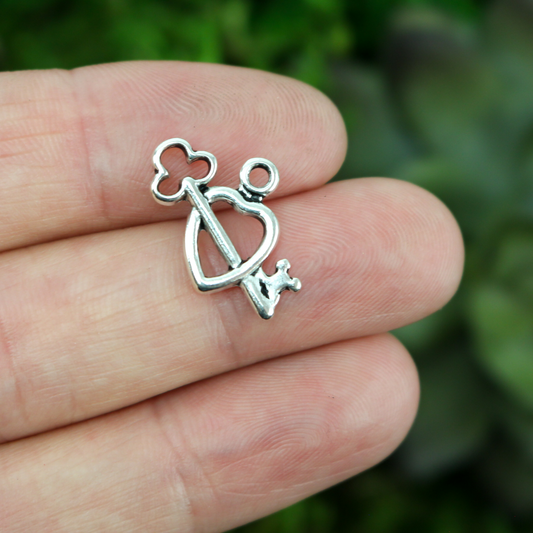 skeleton key through heart charm pendant silver tone in color 14mm long
