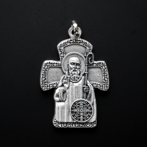 St. Benedict cross-shaped jewelry pendant. The back is inscribed in Spanish with San Benito Protector Contra Los Malos Espíritus y las Tentaciones