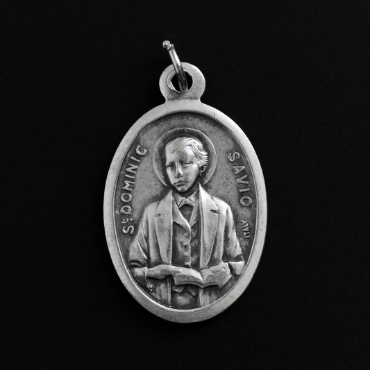Saint Dominic Savio medal that depicts the saint on the front and "Pray For Us" on the back