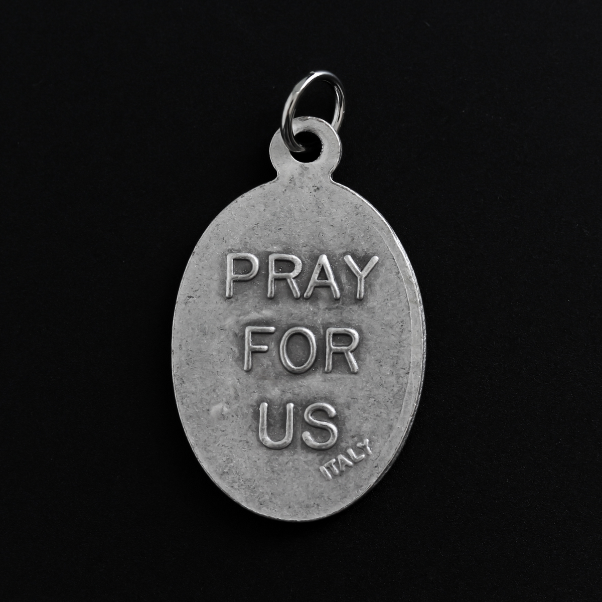 Saint Dominic Savio medal that depicts the saint on the front and "Pray For Us" on the back