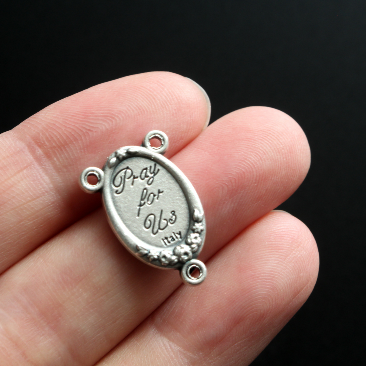 rosary center that has a full-color image of Saint Francis of Assisi inlaid in a silver oxidized center with flower details on the edge