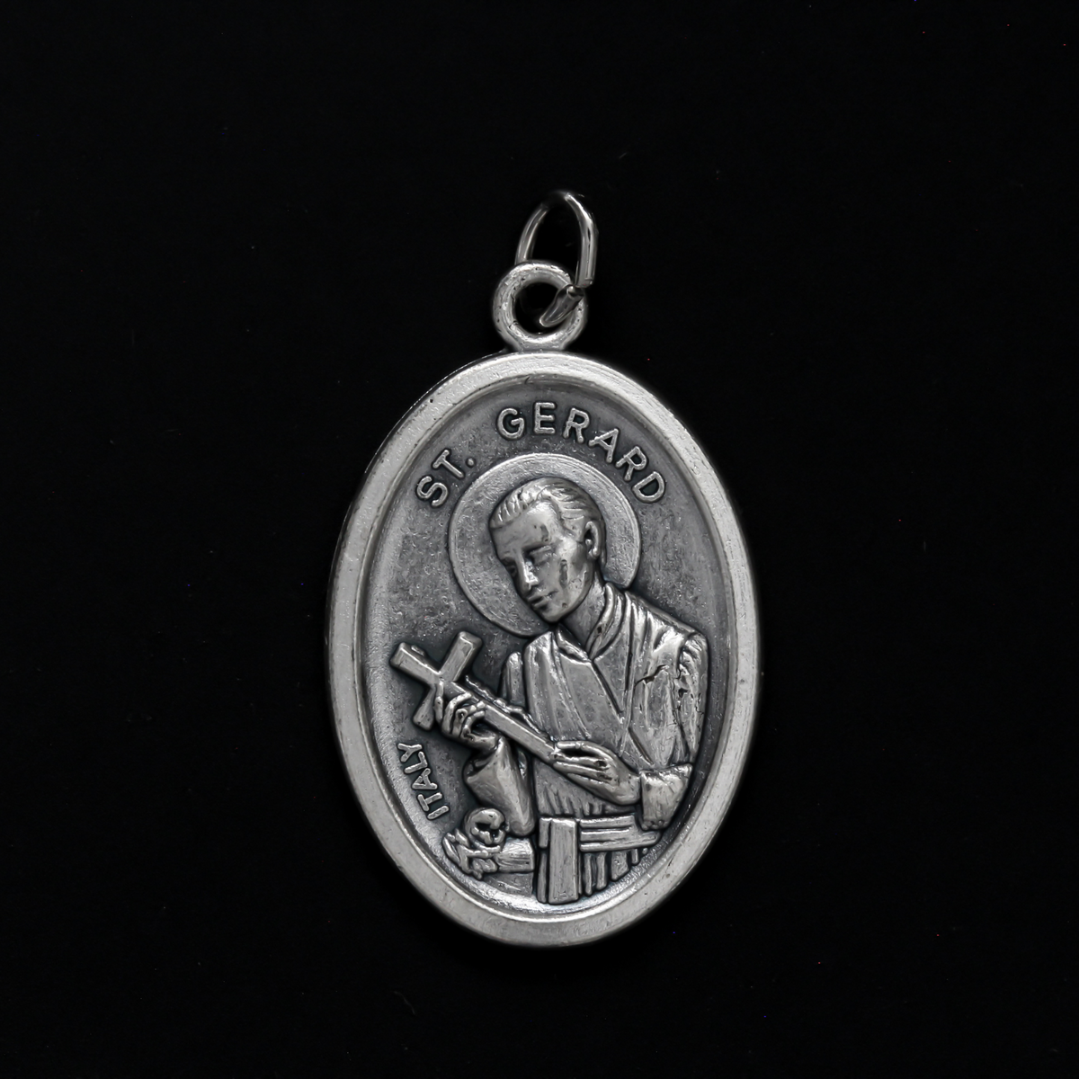 Saint Gerard Majella medal that depicts the saint holding a cross on the front and "Pray For Us" on the back
