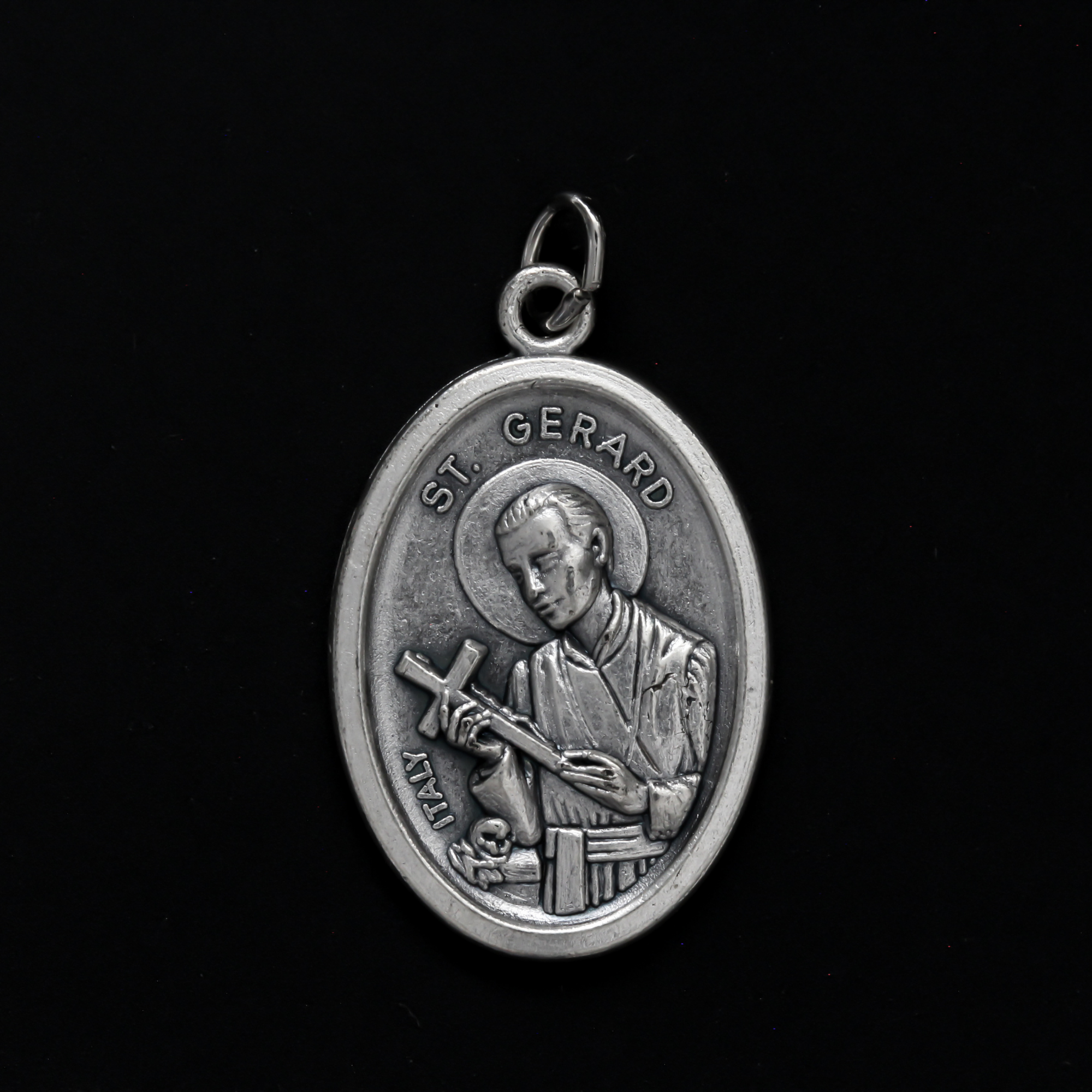 Saint Gerard Majella medal that depicts the saint holding a cross on the front and "Pray For Us" on the back