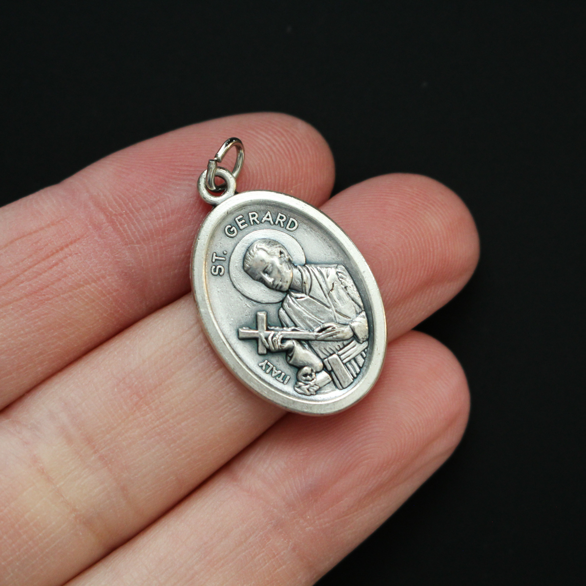 Saint Gerard Majella medal that depicts the saint holding a cross on the front and "Pray For Us" on the back