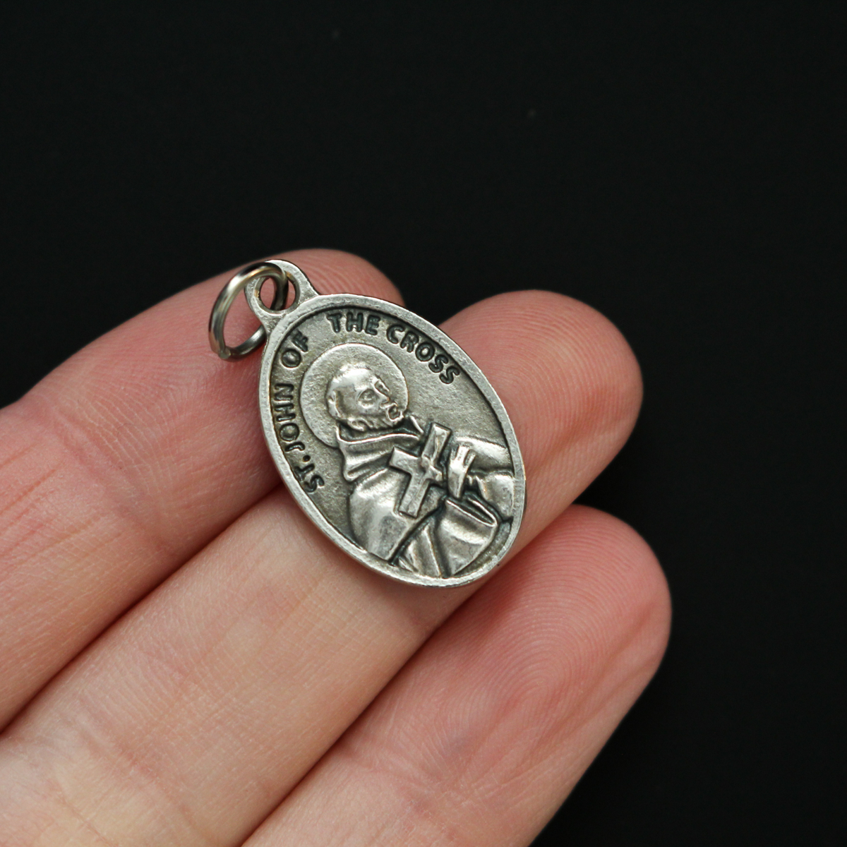 Saint John of the Cross medal that depicts the saint on the front and "Pray For Us" on the back