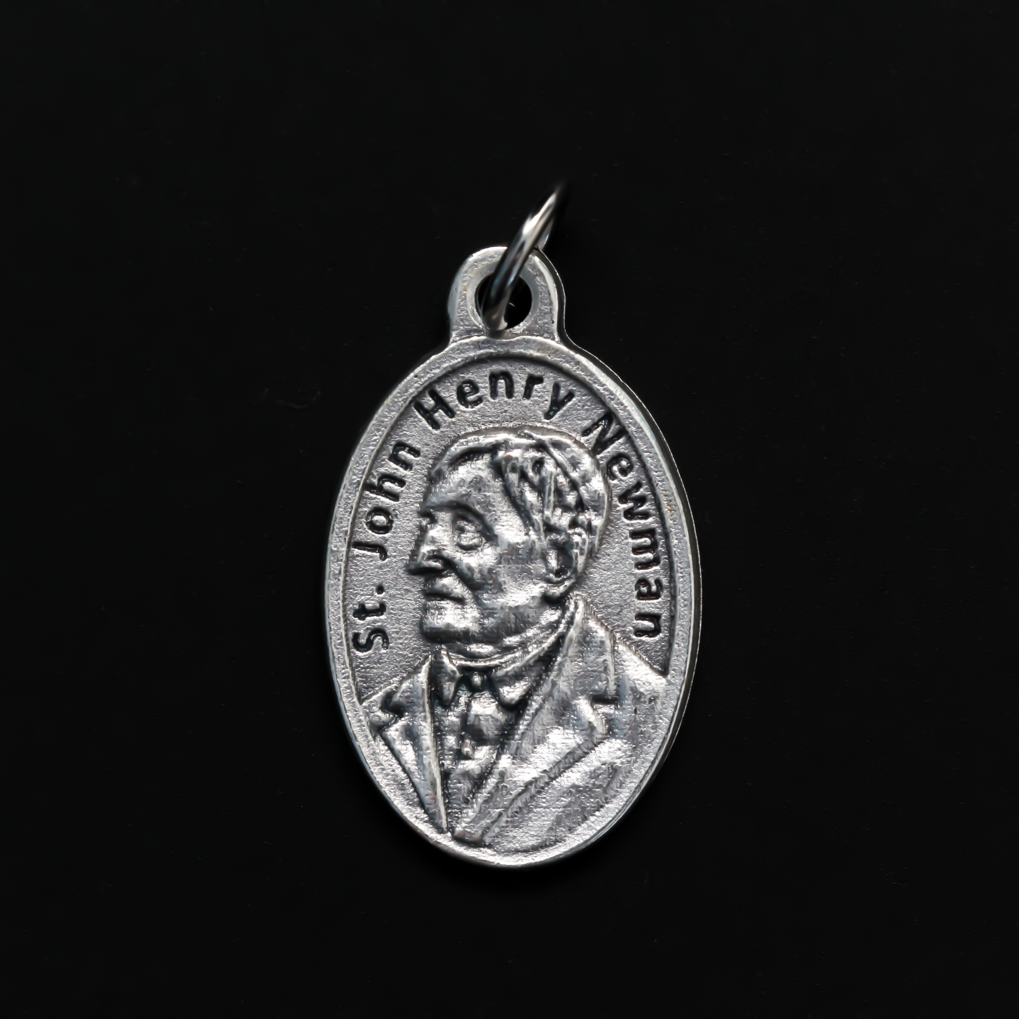 Saint John Henry Newman medal that depicts the saint on the front and is marked "Pray For Us" on the back