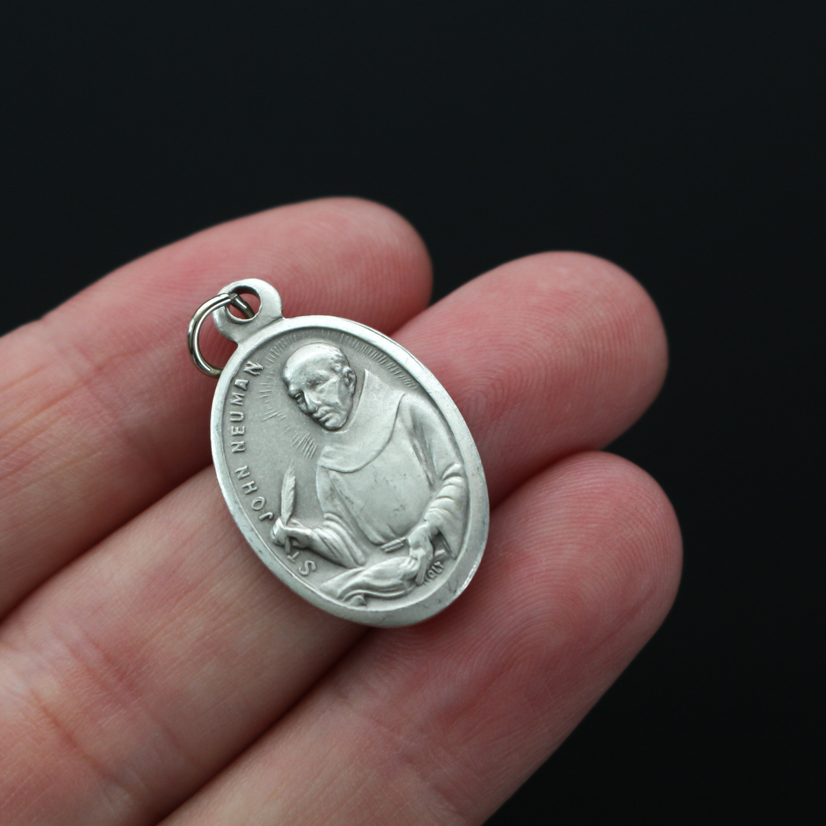 Saint John Neumann medal that depicts the saint on the front and "Pray For Us" on the back.