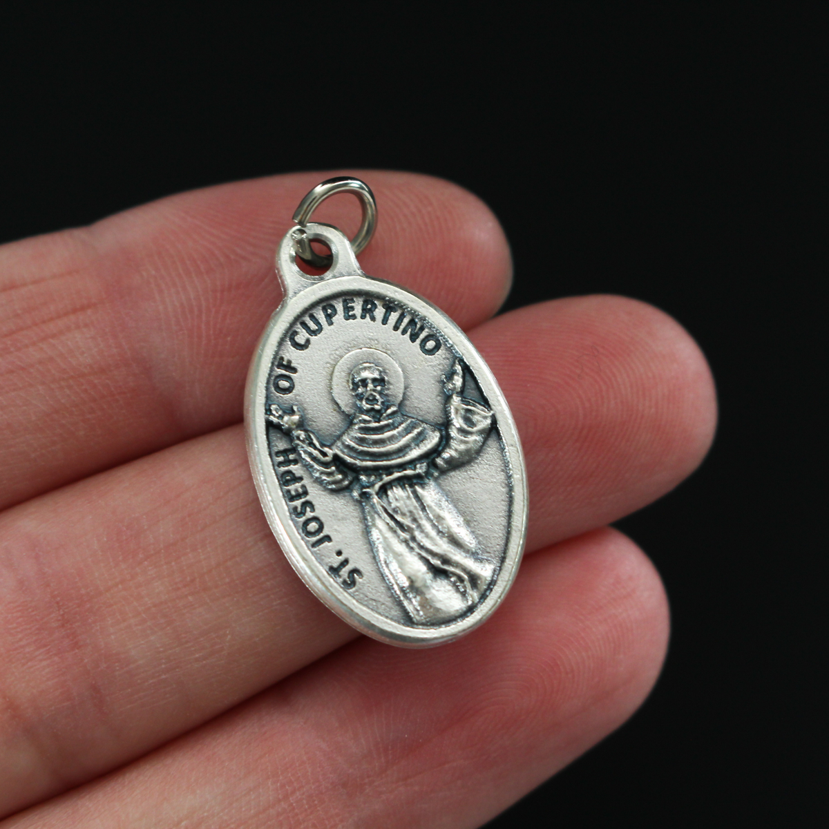Saint Joseph of Cupertino medal that depicts the saint on the front and "Pray For Us" on the backside