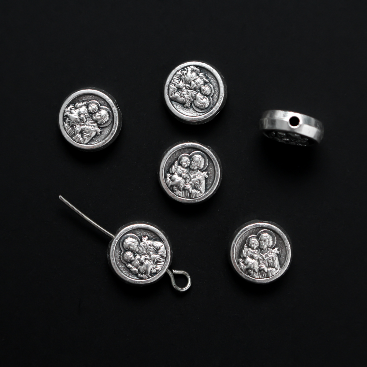 Metal spacer beads with Saint Joseph holding child Jesus on one side and Jesus, Joseph, and Mary on the other side 9.5mm in diameter