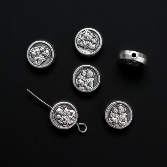 Metal spacer beads with Saint Joseph holding child Jesus on one side and Jesus, Joseph, and Mary on the other side 9.5mm in diameter