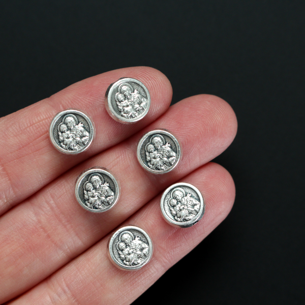 Metal spacer beads with Saint Joseph holding child Jesus on one side and Jesus, Joseph, and Mary on the other side 9.5mm in diameter