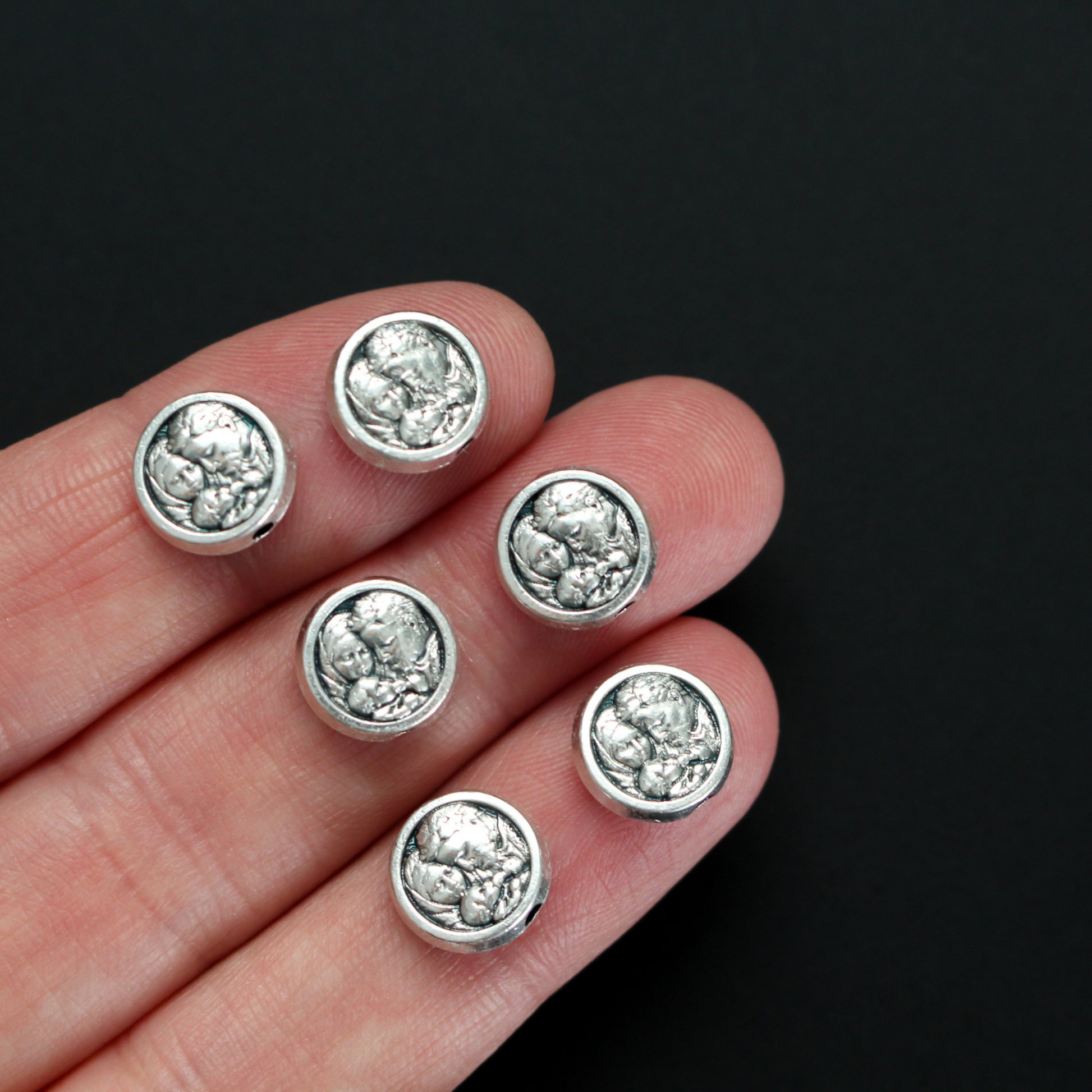 Metal spacer beads with Saint Joseph holding child Jesus on one side and Jesus, Joseph, and Mary on the other side 9.5mm in diameter