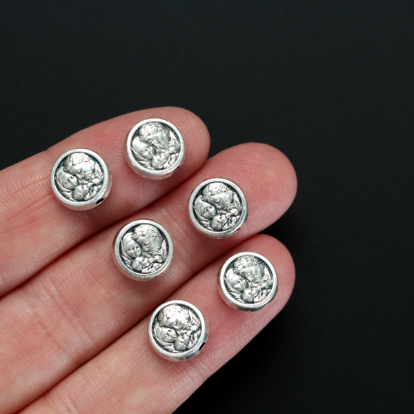 Metal spacer beads with Saint Joseph holding child Jesus on one side and Jesus, Joseph, and Mary on the other side 9.5mm in diameter